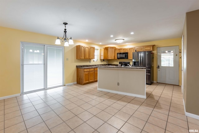 kitchen featuring black appliances, pendant lighting, light tile patterned floors, an inviting chandelier, and a kitchen island