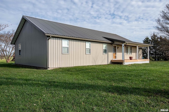 back of house featuring covered porch and a lawn