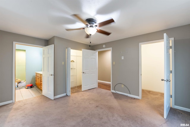 unfurnished bedroom with connected bathroom, ceiling fan, and light colored carpet