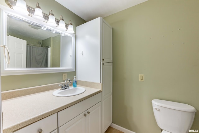 bathroom with a shower with shower curtain, vanity, and toilet