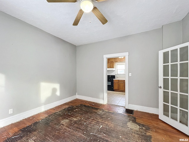 empty room with wood-type flooring, a textured ceiling, and ceiling fan