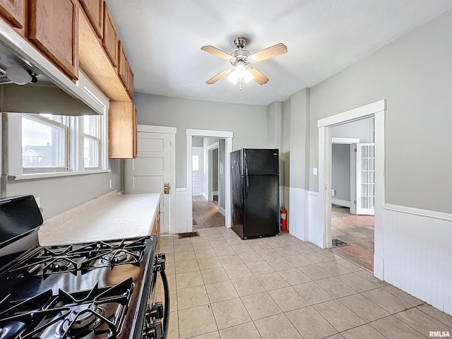 kitchen with black appliances, ceiling fan, and light tile patterned flooring