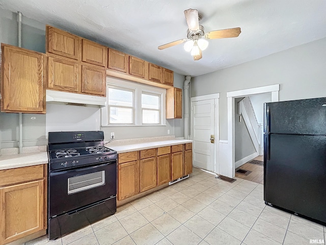 kitchen with black appliances, ceiling fan, and light tile patterned floors