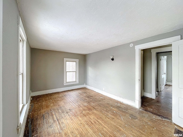 empty room featuring hardwood / wood-style flooring and a textured ceiling