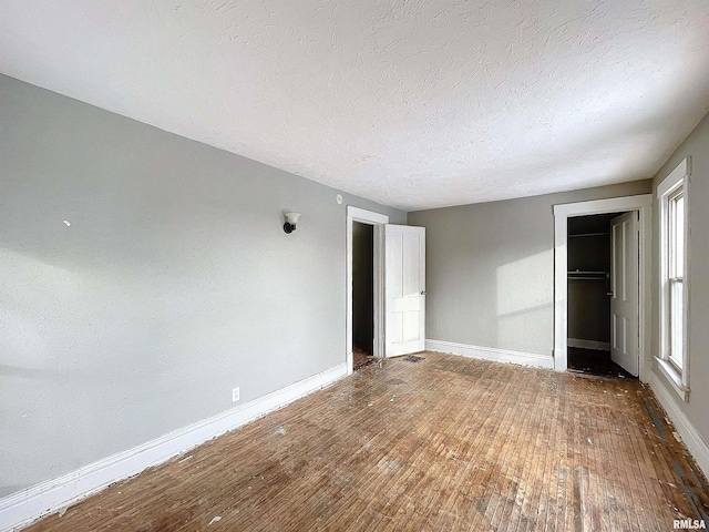 unfurnished bedroom with a closet, hardwood / wood-style floors, and a textured ceiling