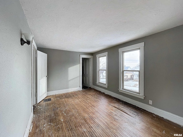 unfurnished room featuring a textured ceiling and hardwood / wood-style flooring