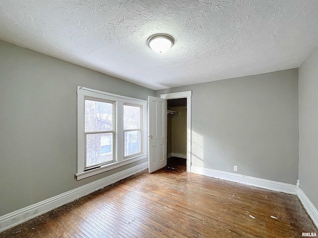 unfurnished bedroom with a closet, wood-type flooring, and a textured ceiling