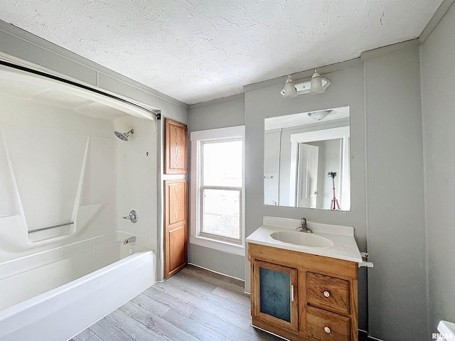 bathroom featuring vanity, a textured ceiling, hardwood / wood-style flooring, and shower / washtub combination