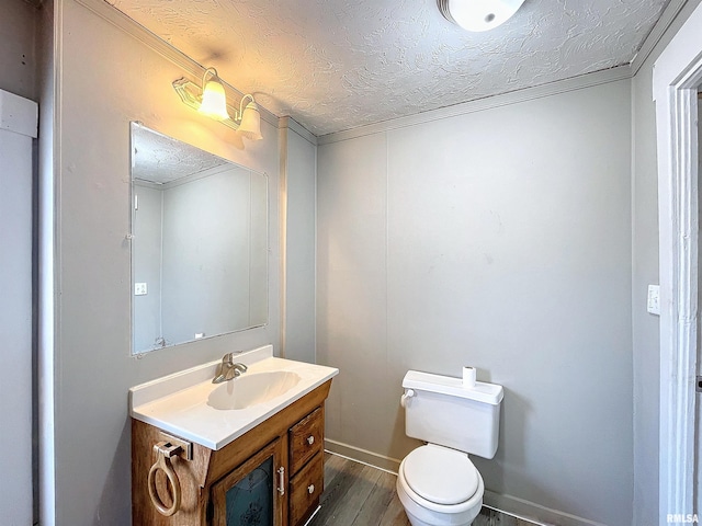 bathroom featuring vanity, a textured ceiling, hardwood / wood-style flooring, and toilet