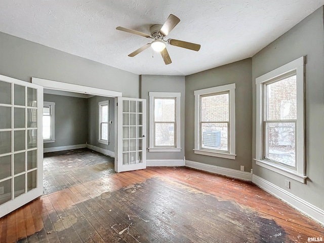 spare room featuring ceiling fan, french doors, wood-type flooring, and a textured ceiling