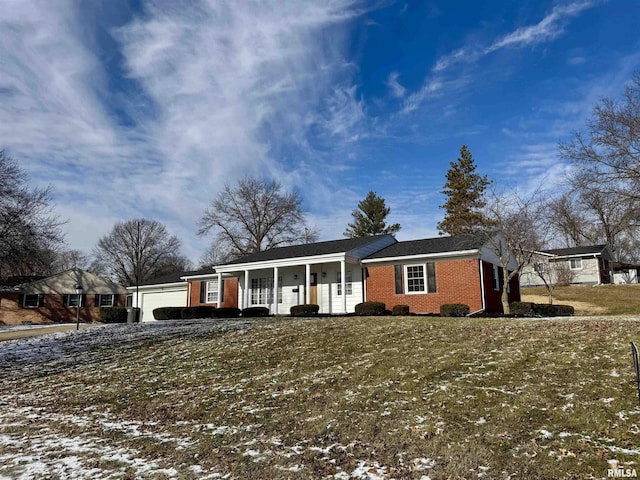 ranch-style house featuring a garage, covered porch, and a yard