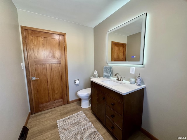 bathroom with vanity, hardwood / wood-style flooring, and toilet