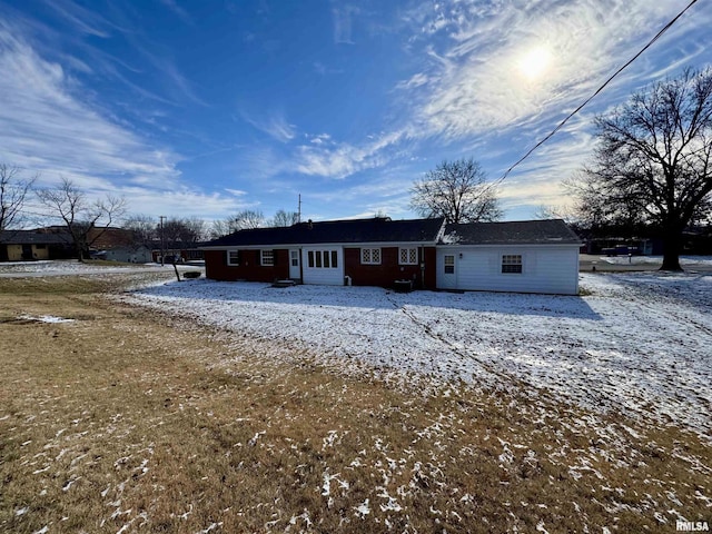 view of snow covered back of property