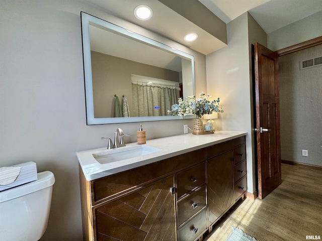 bathroom featuring vanity, hardwood / wood-style flooring, and toilet