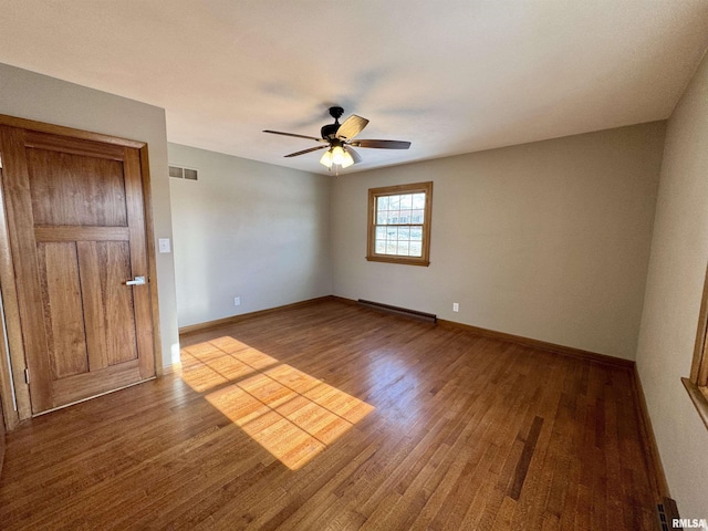 empty room with light hardwood / wood-style floors, ceiling fan, and a baseboard heating unit