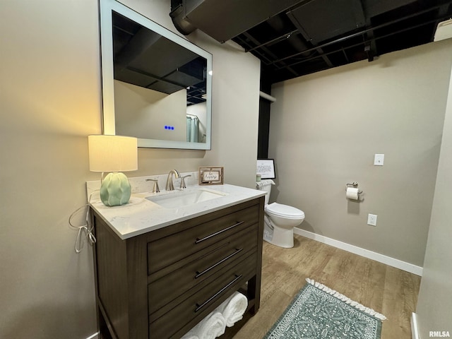 bathroom featuring wood-type flooring, vanity, and toilet