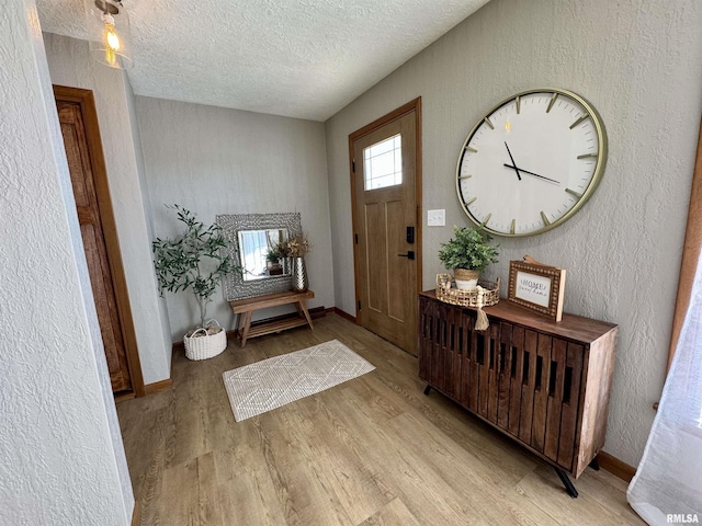 foyer entrance with a textured ceiling and light wood-type flooring