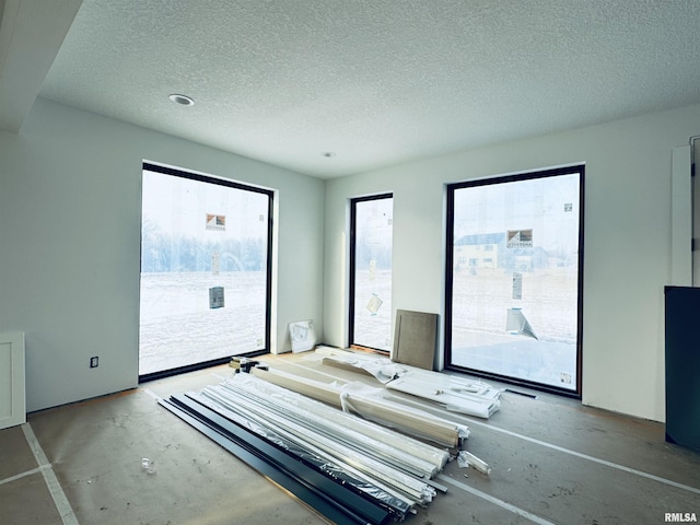 unfurnished bedroom featuring access to exterior and a textured ceiling