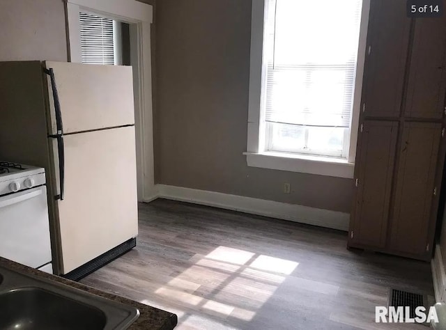 kitchen featuring white appliances, light hardwood / wood-style flooring, and sink