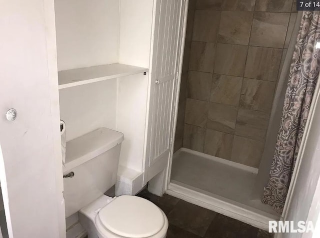 bathroom featuring a shower with curtain and toilet