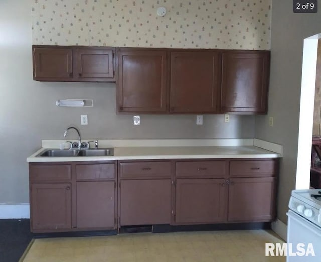 kitchen with dark brown cabinetry, white range with electric cooktop, and sink