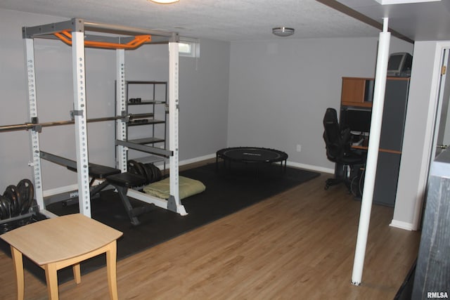 exercise room with a textured ceiling and hardwood / wood-style flooring