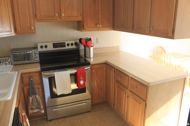 kitchen featuring decorative backsplash and stainless steel range with electric stovetop