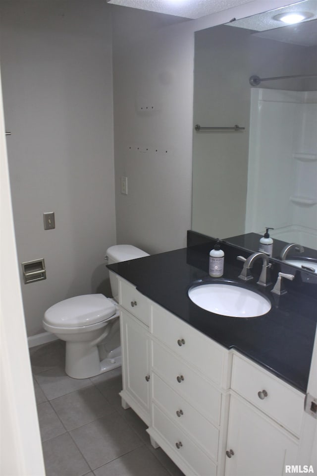 bathroom featuring tile patterned flooring, vanity, and toilet