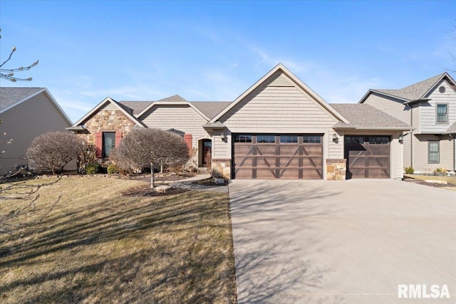 view of front of home with stone siding, concrete driveway, a garage, and a front yard