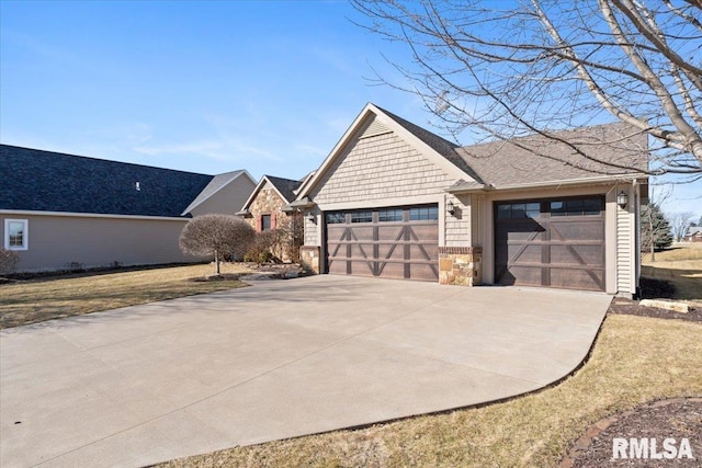 view of side of home with stone siding, concrete driveway, and a garage