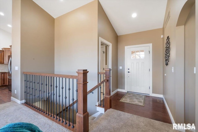 entrance foyer with baseboards, lofted ceiling, and carpet flooring