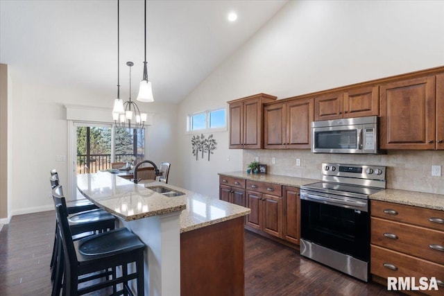 kitchen with a healthy amount of sunlight, stainless steel appliances, an inviting chandelier, and a sink