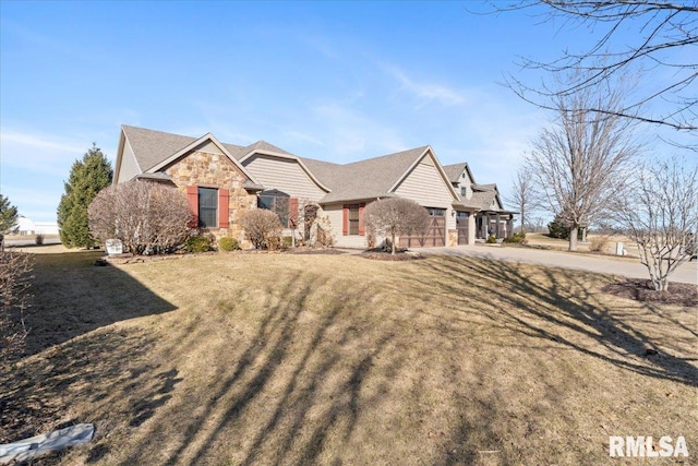 view of front of property with stone siding, a garage, concrete driveway, and a front lawn