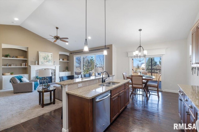 kitchen with built in shelves, a fireplace, dark wood-style flooring, a sink, and stainless steel dishwasher