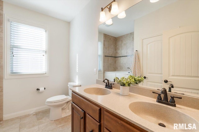 bathroom featuring a wealth of natural light, a tile shower, and a sink