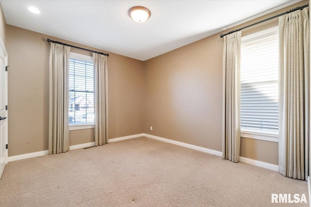 carpeted empty room featuring baseboards