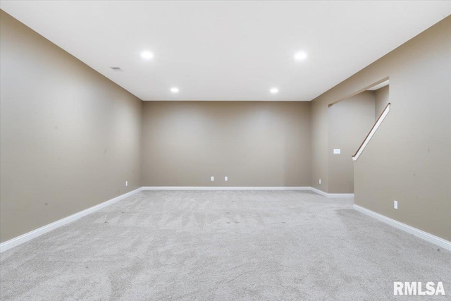 basement featuring light colored carpet, visible vents, recessed lighting, and baseboards