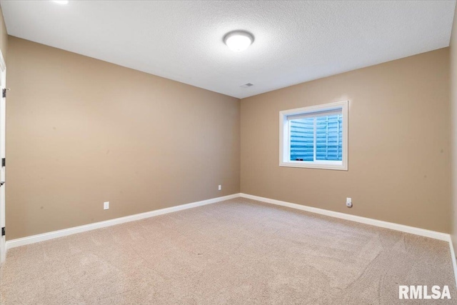 unfurnished room with carpet flooring, visible vents, baseboards, and a textured ceiling