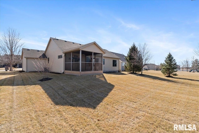 back of house featuring a lawn and a sunroom