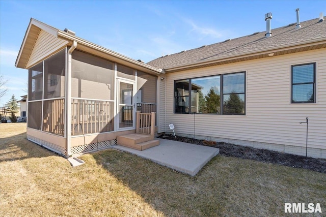 rear view of property featuring a shingled roof, a yard, and a sunroom