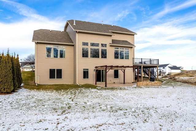 snow covered property featuring a pergola, a patio area, and a wooden deck