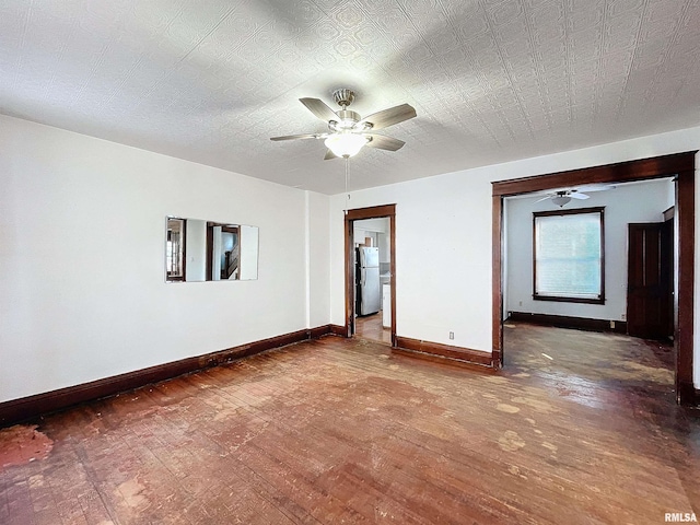 empty room with ceiling fan, dark hardwood / wood-style flooring, and a textured ceiling