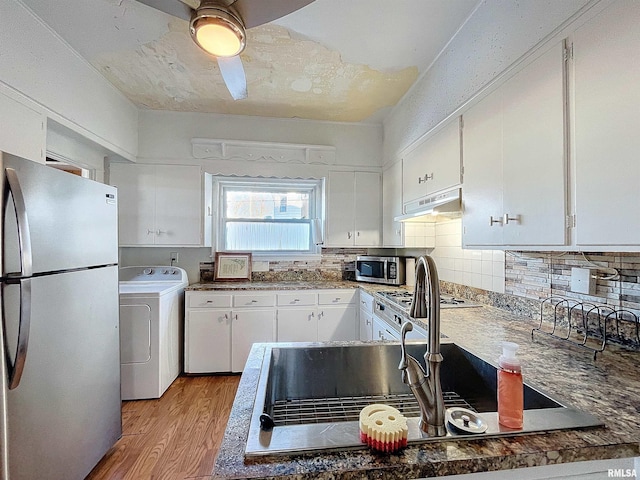 kitchen featuring washer / dryer, decorative backsplash, light hardwood / wood-style flooring, appliances with stainless steel finishes, and white cabinets