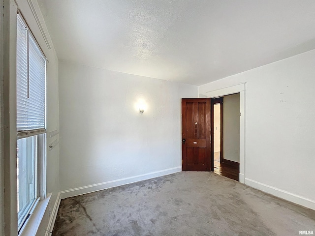 unfurnished room featuring a textured ceiling and carpet flooring