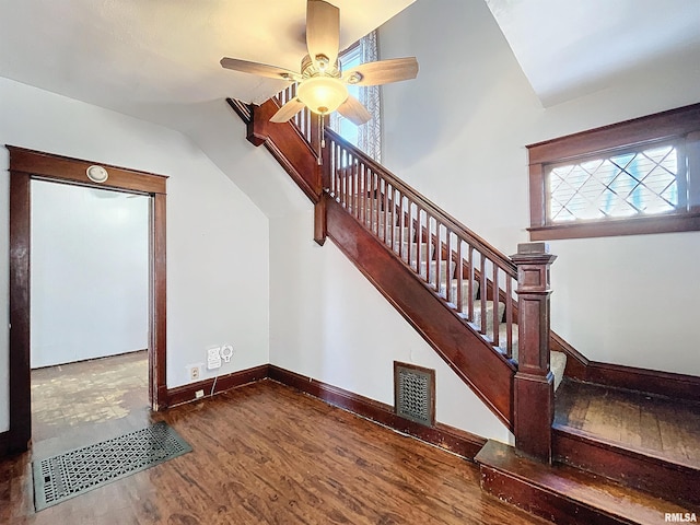 stairs featuring ceiling fan, hardwood / wood-style floors, and lofted ceiling