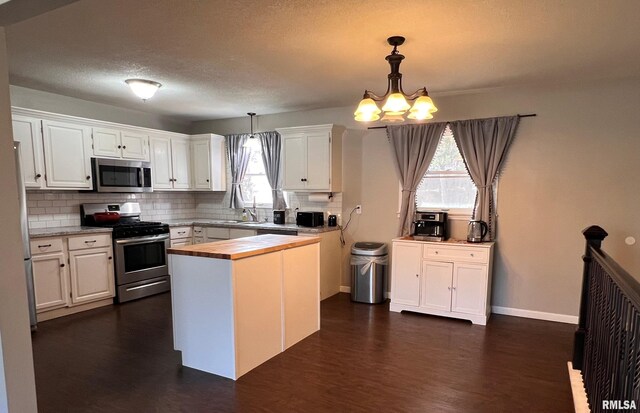 kitchen with white cabinets, appliances with stainless steel finishes, sink, and tasteful backsplash