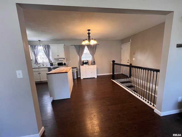 2433 Cedar Creek Ct, Quincy, IL 62305 - kitchen with pendant lighting, butcher block countertops, an inviting chandelier, dark hardwood / wood-style floors, and white cabinets