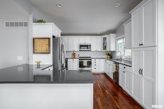 kitchen featuring sink, white cabinetry, kitchen peninsula, and appliances with stainless steel finishes