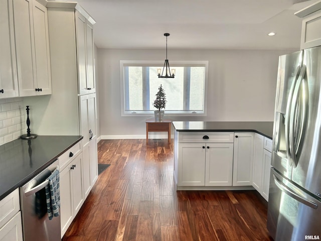 kitchen featuring decorative backsplash, stainless steel appliances, dark wood-type flooring, white cabinetry, and hanging light fixtures