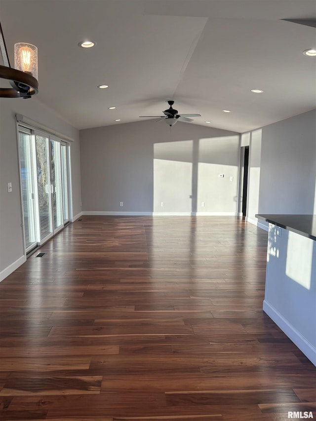 unfurnished living room with ceiling fan, dark wood-type flooring, and vaulted ceiling